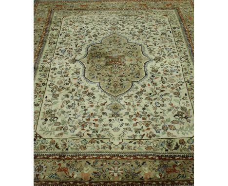 An Indian rug, the central panel set with floral decorated medallion on a cream and floral decorated ground within a stepped 