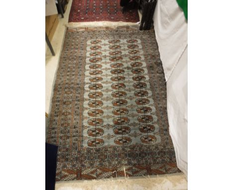 A Bokhara rug, the central panel set with three rows of repeating elephant medallions on a pale blue ground within a stepped 