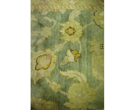 A Ziegler design carpet, the central panel with all over floral decoration, within a stepped mustard and green floral decorat