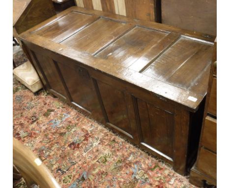A circa 1700 oak coffer, the four panelled top within plain stiles with original ring hinges over a similarly decorated four 