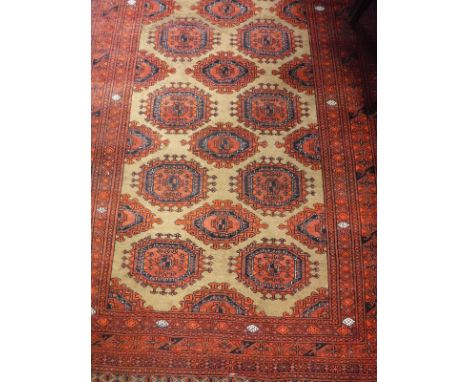 A Beluch rug, the central panel set with repeating medallions on a brown ground, within a red and black stepped, geometric pa