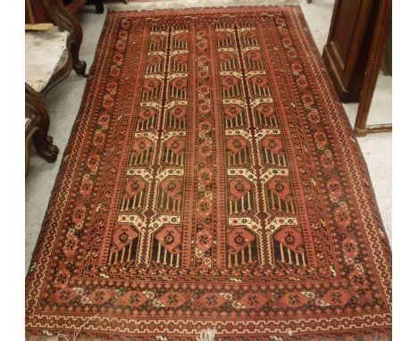 A Bokhara carpet, the central panel set with repeating hook motifs on a red and black ground within a stepped geometric patte