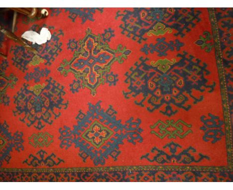 A Turkish rug, the central panel set with repeating motifs on a red ground within a stepped red, blue and green patterned bor