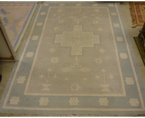 A Caucasian carpet, the central panel set with three multicoloured medallions on a cream ground with stylised bird and animal