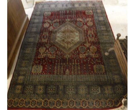 A Bokhara rug, the central panel set with repeating medallions on a fawn ground within a stepped geometric patterned red and 