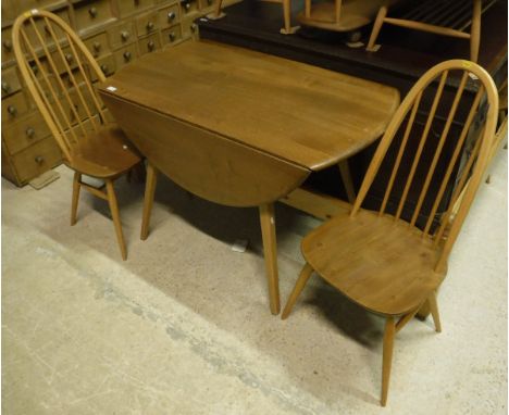 A blond Ercol drop-leaf dining table on stick legs together with four blond Ercol stickback kitchen chairs 
