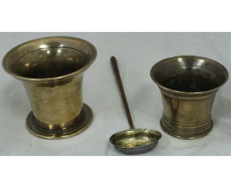 Two 18th Century bell metal mortars and a wooden handled white metal punch ladle, the bowl inset with a George III coin dated