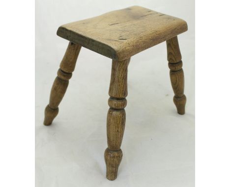 A 19th Century elm milking stool together with a cast metal painted stick stand containing various sticks to include one with