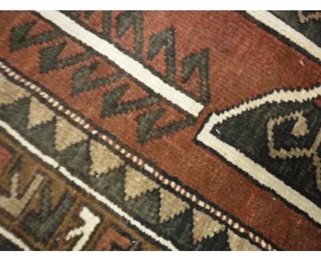 A Caucasian rug of Sewan Kazak design, the central panel set with a lozenge shaped medallion on a brown, red and olive green 