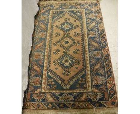 A Caucasian rug, the central panel set with three repeating medallions with taratula style decoration on a pale pink ground w