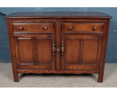 An Ercol dark Old Colonial sideboard, with two drawers over panelled doors.  