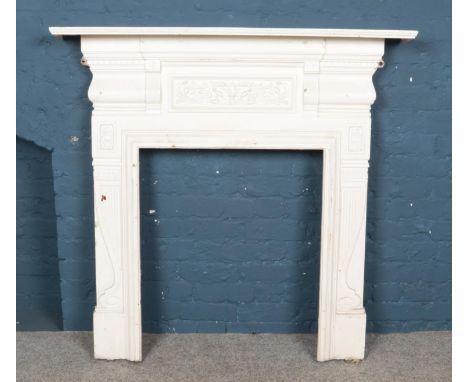 A large white painted cast iron fireplace with central floral plaque. Height: 123cm, Width: 124cm.  