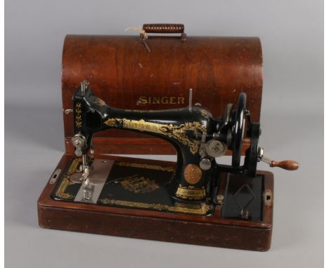 A dome top cased singer sewing machine, numbered Y7033976.  Some enamel loss and age related wear.