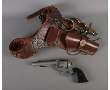 A 1974 model replica army 45 western revolver along with gun holster and spurs.  