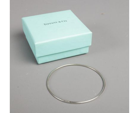 A boxed Tiffany and Co. silver bangle, marked to band and stamped 925. Weight: 5.5g  Slight scratches. Would benefit from a c