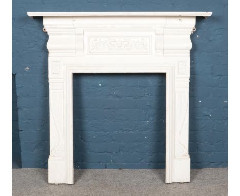 A large white painted cast iron fireplace with central floral plaque. Height: 123cm, Width: 124cm.  