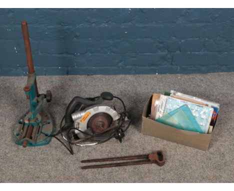 A box of tools including circular saw, tongs, box of measuring tools, etc.  