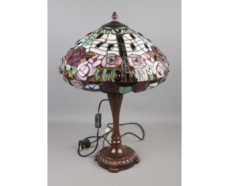 A Tiffany style table lamp featuring rose floral decoration.  Shade missing nut at top, loose and wobbly.