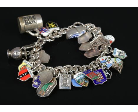 A continental silver charm bracelet with charms, most stamped 800. Charms include horseshoe, tankard, urn and enamel crests. 