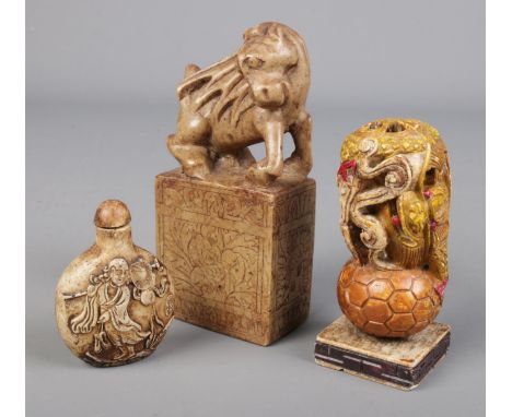 Three Chinese items. Includes carved bone snuff bottle, hardstone mythical beast on plinth and a seal with dragon decoration.