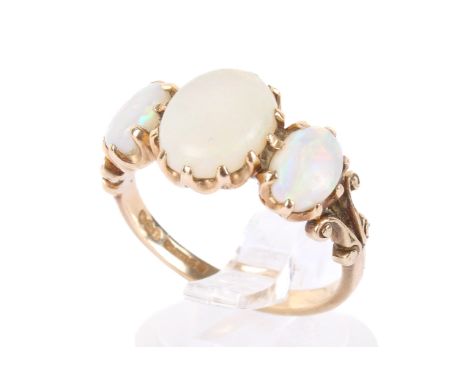 A 9ct gold and opal three stone ring. The three oval opals set in a mount with scrolling details, size Q/R, 3.3g gross Condit