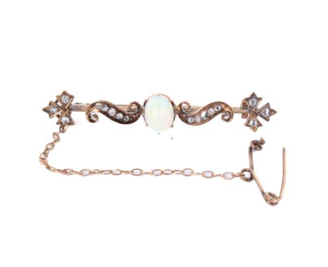 A gold and diamond bar brooch. The central oval white opal of circa 7mm x 5mm flanked by scrolls and three-leafed sprigs set 