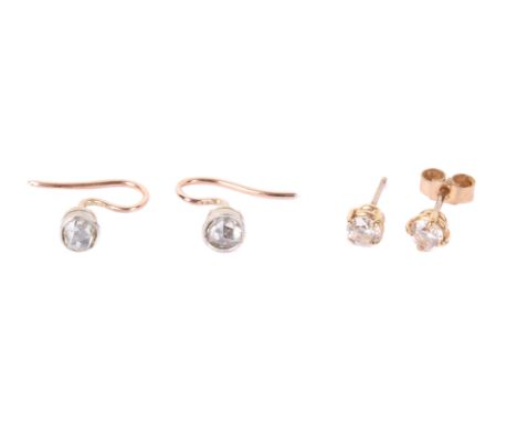 A pair of diamond single earrings and another pair. The cushion cut diamonds circa 0.4cm diameter, on unmarked yellow metal l