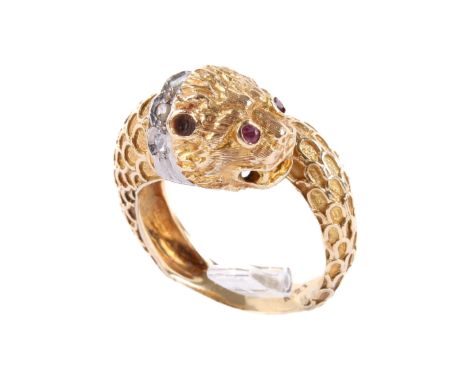 A LALAoUNIS designer yellow metal 'lion' ring. Circa 1970, the textured band of crossover design terminating in a stylised li