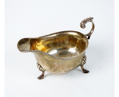 A silver sauce boat, Harrison Brothers & Howson, Sheffield 1929, of typical form with gadrooned rim and raised on three stepp