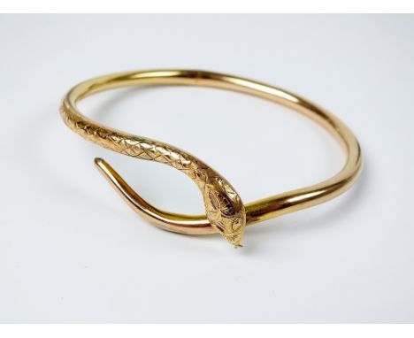 A yellow metal hollow snake bangle, stamped '9ct', weight 10gms