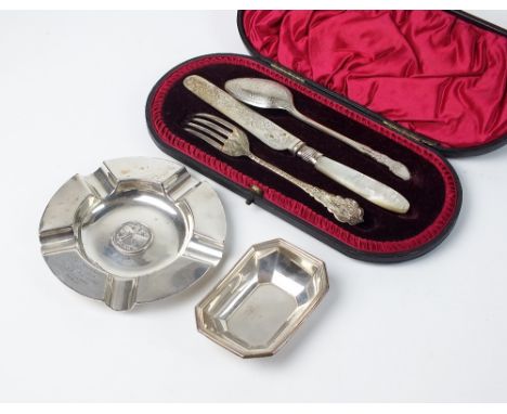 A matched cased silver christening set, comprising; spoon, knife and fork, together with a silver ash tray and silver pin dis