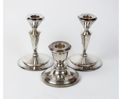 A pair of silver mounted candlesticks, James Deakin & Sons, Birmingham 1911, 12cm high, together with a further silver mounte