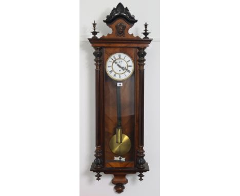 A late 19th/early 20th century Vienna-type wall clock with black roman numerals to the white enamel dial, &amp; in a mahogany