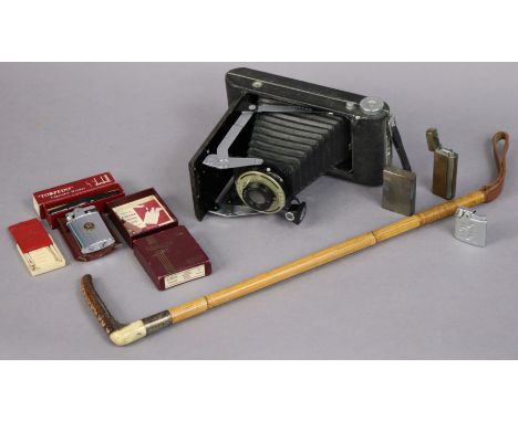 A riding crop with a horn handle &amp; with a plated collar; a Kodak folding camera; a Dunhill “Torpedo” cigarette lighter; &