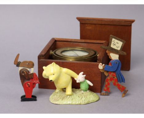 An oriental brass-cased gimbal compass, with a treen travelling case; together with a Royal Doulton figure group “Pooh &amp; 