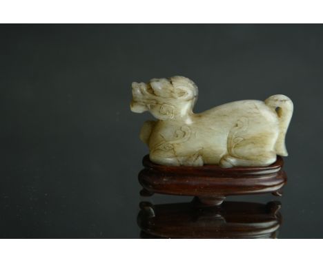 Chinese jade carving of a recumbent horse, its legs tucked under its body with its head raised and facing forward, wood stand