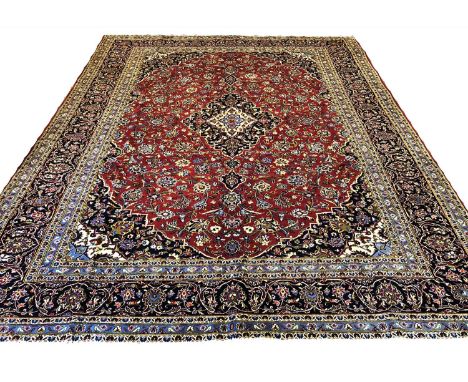 FINE KASHAN CARPET, 362cm x 281cm, pendant medallion on a ruby field of palmettes and vines within complimentary spandrels, b