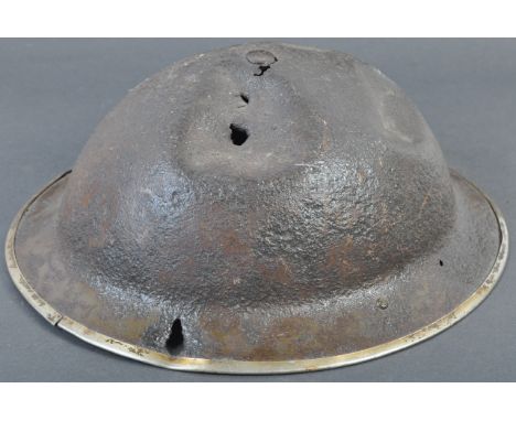 An original WWII Second World War British Army steel combat ' battle damaged ' brodie helmet. The helmet of typical form, wit