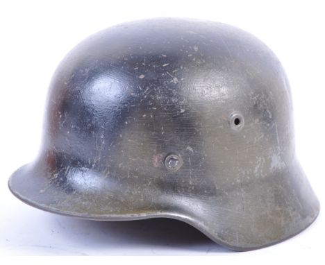 A rare original WWII Second World War Nazi German Army M35 Stahlhelm steel combat helmet, with camouflage paint scheme. The i