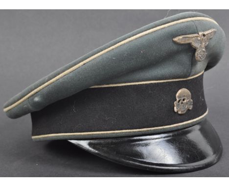 A WWII Second World War related Third Reich Nazi German Waffen SS Officer's peaked cap. The green felt hat having a black cen