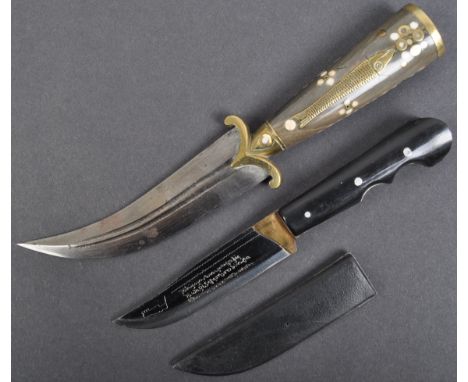 Two vintage 20th century Islamic / Arabic daggers - the first a Jambiya type curved dagger with a decorative horn and brass h