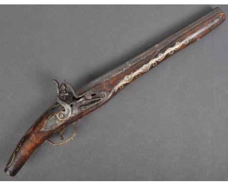 An early 20th Century Moroccan axe head flintlock pistol / gun. The wooden stock decorated with inlaid gilt metal of spiral m
