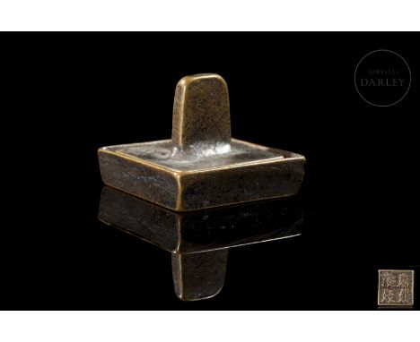 Bronze with traces of gilt patina. It consists of two pieces, the first, a small square container with fine edges designed to