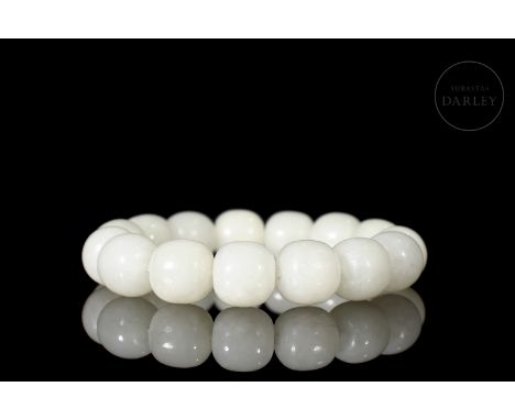 Elegant carved white jade, in the form of small spherical beads, slightly flattened at the ends, and pierced by a central hol