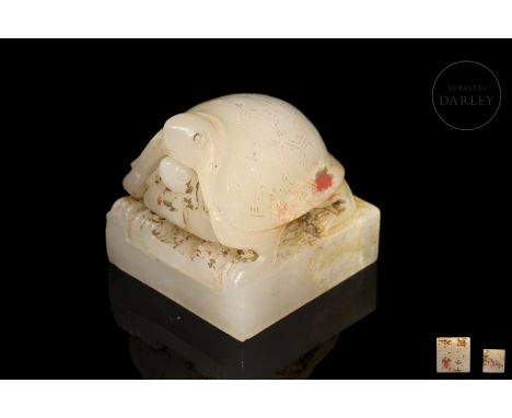 Small carved white jade seals, one larger, with a central cavity into which the second smaller one is inserted. Both show tur