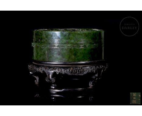 Made of beautifully carved jade of an intense spinach-green colour, with flecks of darker tonality. It has a flat circular bo