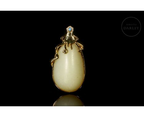Oval-shaped, carved white jade, framed by a gold-plated silver frame, added later, adorned with gem-set stones and long ribbo