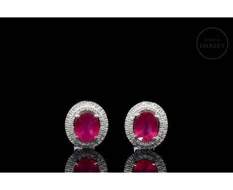 Button earrings with two central oval-cut rubies, with a total weight of 6.28 ct. They are surrounded by two 104 brilliant-cu