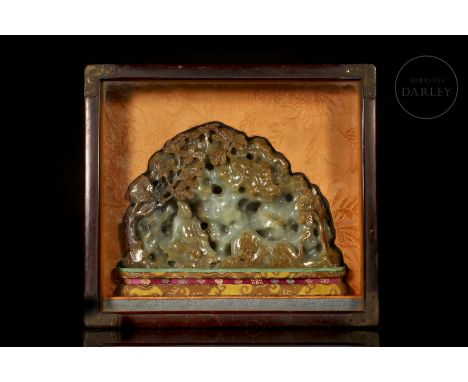 Greenish jade with reddish and brownish flecks. It is shaped like a steep grotto, with openwork recesses and relief detailing