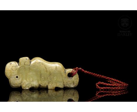 Green jade carved with subtle reddish-ochre flecks. It depicts a crouching tiger, following archaic models, with bent legs, a